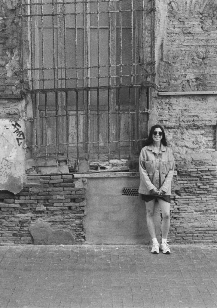 fotografía callejera retrato en blanco y negro mujer apoyada en pared en Valencia