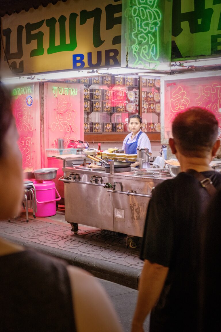 Fotografía callejera en Chinatown de Bangkok, mujer en puesto de comida