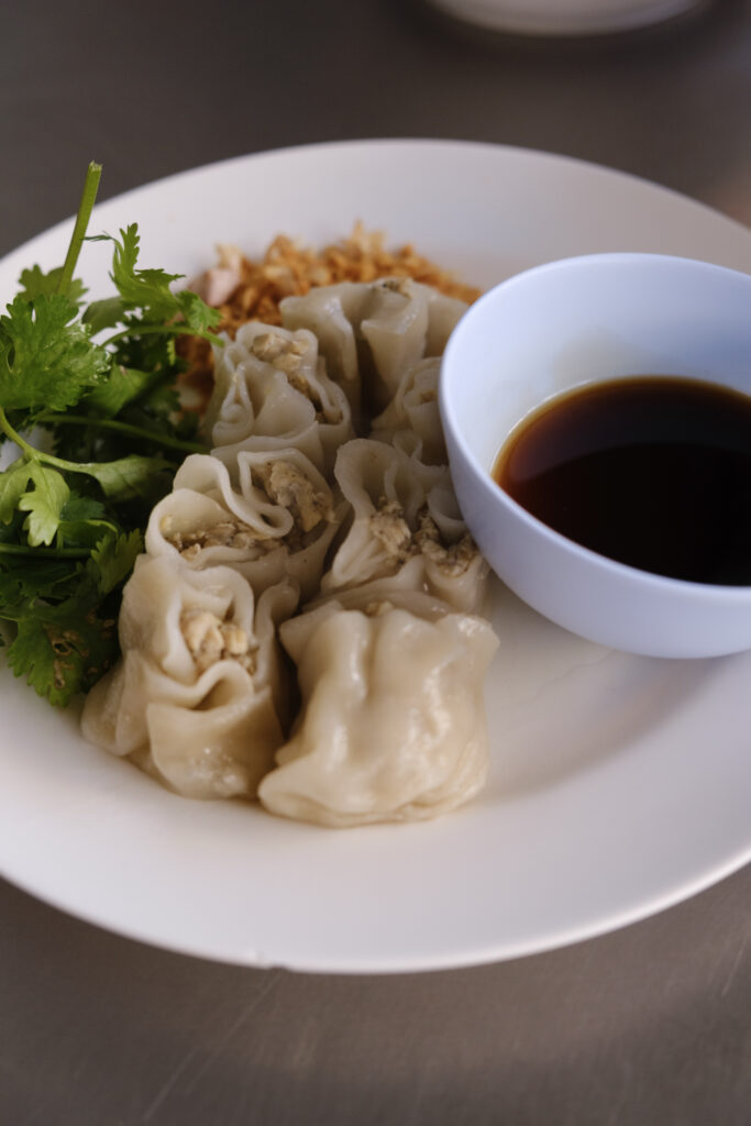 fotografía de plato de dumplings al vapor chinos con salsa de soja